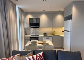 A modern kitchen with a built-in oven, microwave, and a large refrigerator. - Ulu Residence Alanya (Alanya)