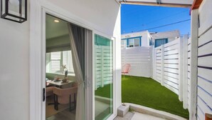 Un espacio exterior estrecho con un ventanal corredero que da a un patio.