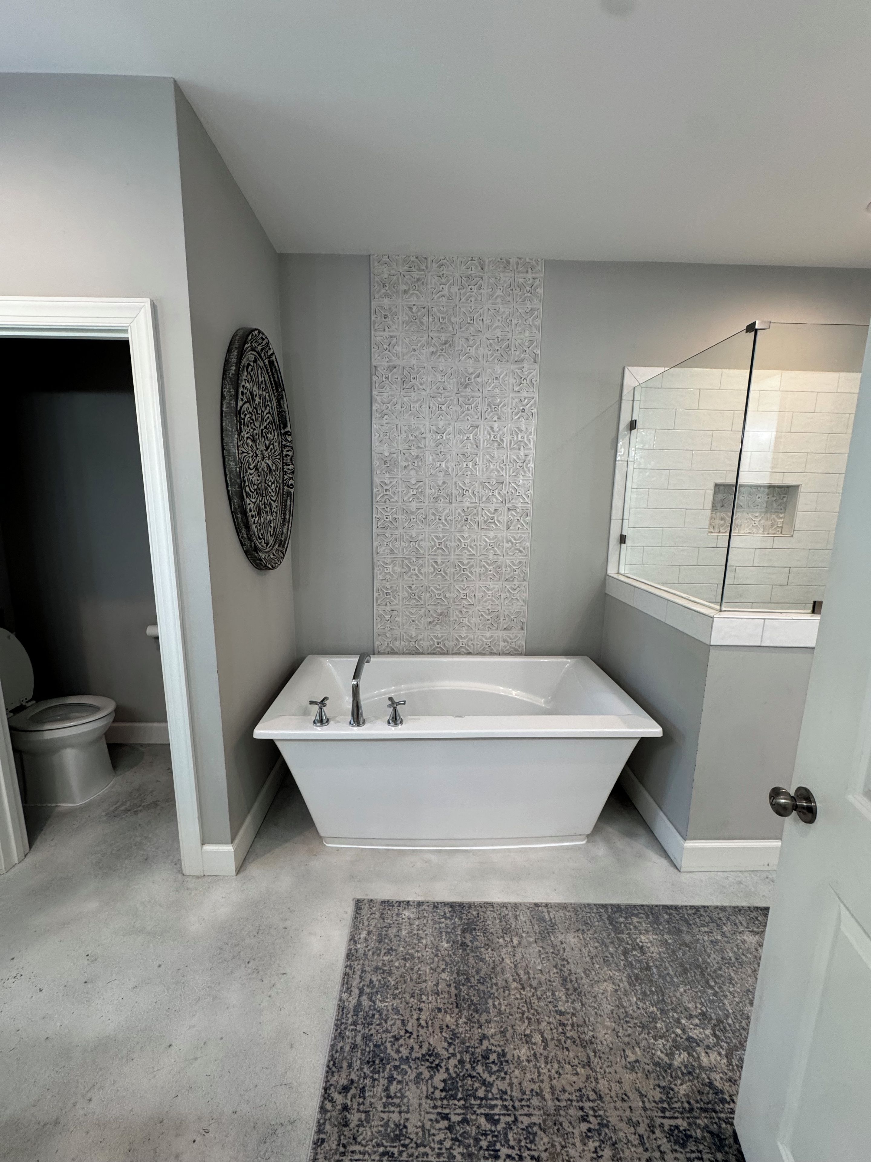 Une salle de bain comprenant une baignoire sur pieds, des toilettes et un espace douche.