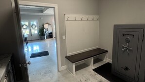 Een kamer met een bankje, een kluisje en een deur naar een andere ruimte.