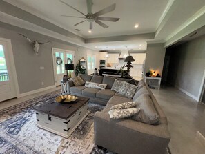 A modern living room with a sectional sofa, a coffee table, and a ceiling fan.