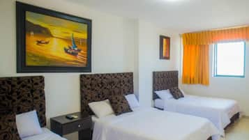 A hotel room with two beds, a nightstand, a painting of a sunset over water, and a window with curtains.