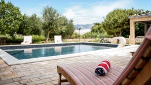 Une piscine avec des chaises longues et une vue sur les montagnes.