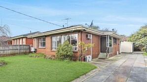 A single-story brick house with a front yard, a garage, and a satellite dish. - Retro Retreat - Mornington (Mornington)