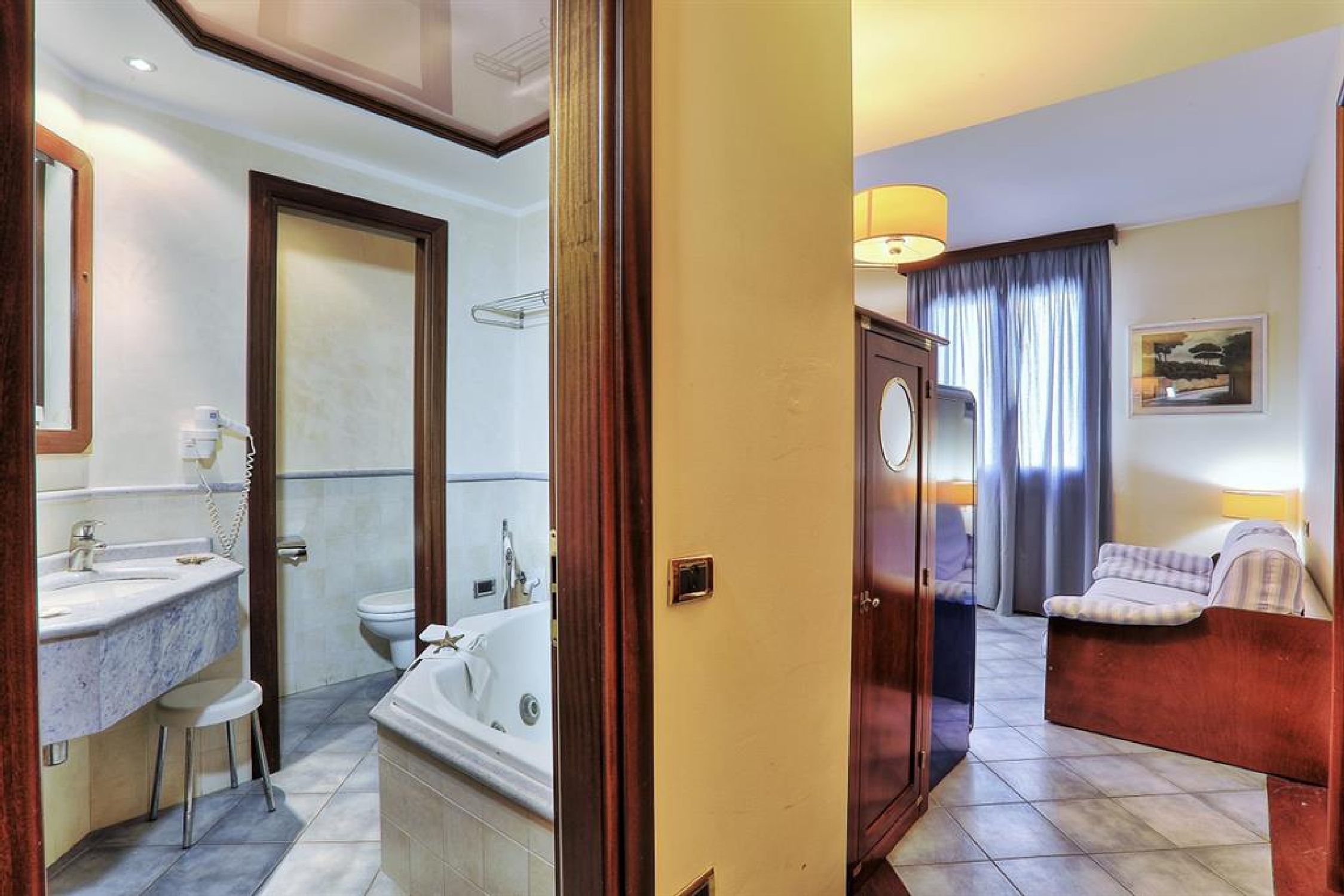 Un bagno d'albergo con vasca, water e lavabo.