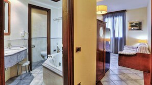 A hotel bathroom with a bathtub, toilet, and sink. - Zì Maria (Cecina)
