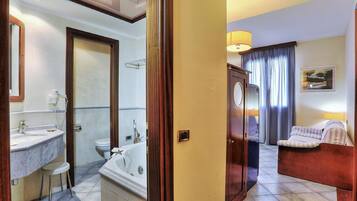 Un bagno d'albergo con vasca, water e lavabo.