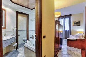 A hotel bathroom with a bathtub, toilet, and sink. - Zì Maria (Cecina)