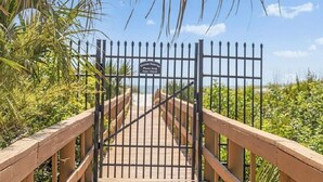 A wooden boardwalk leading to a gated entrance with a sign that reads "Ocean Shores Please Keep Gate Closed." - Lovely and affordable oceanfront retreat, just steps from St. Augustine Beach (St. Augustine)