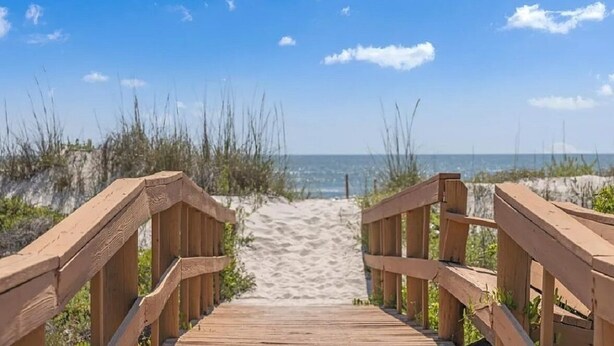 A wooden boardwalk leading to a sandy beach with the ocean in the background. - Lovely and affordable oceanfront retreat, just steps from St. Augustine Beach (St. Augustine)