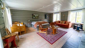 A cozy room with a bed, a sofa, a dining table, and a chair. - Roisheim (Lom)
