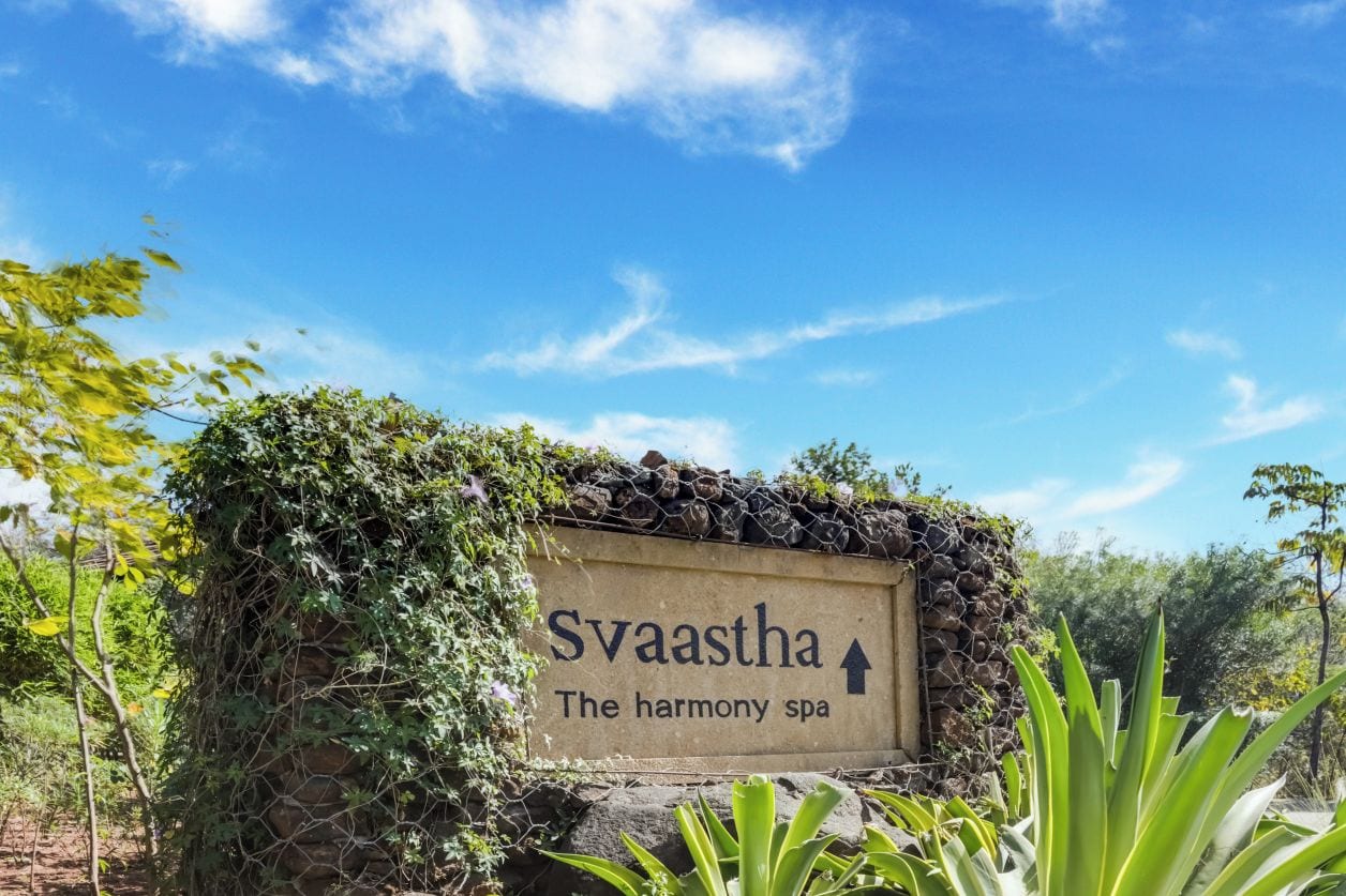 A sign for Svaastha The Harmony Spa with an arrow pointing upwards.