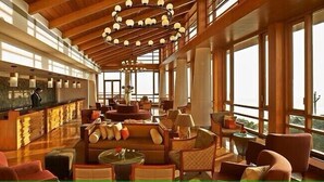 A spacious lobby with a high ceiling, large windows, and a central seating area. - Club Mahindra Resort - Tungi (Ootacamund)
