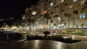 A multi-story hotel with balconies, a wooden deck, and palm trees. - VV Miramar Sunset Tabaiba (Tabaiba)