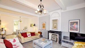 A living room with a sofa, coffee table, fireplace, and a television. - Awesome home in Thézan-des-Corbières (Thézan-des-Corbières)