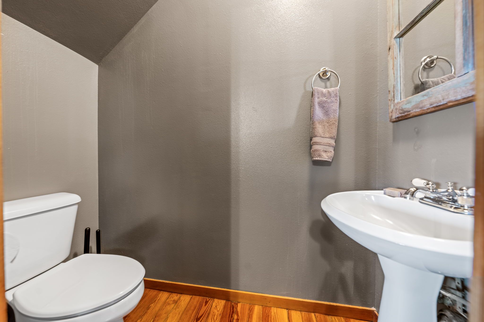 A bathroom with a toilet, sink, and towel rack.