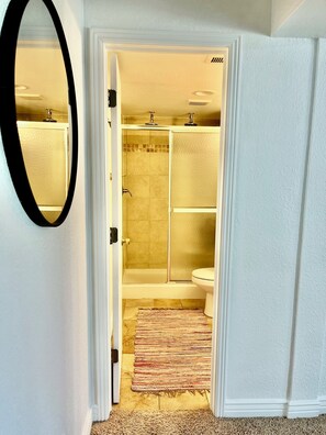 A bathroom with a shower, toilet, and a mirror. - Private Entrance\Modern&Cozy Central Bliss\King Villa\55" 4k Roku\Full Kitchen (Colorado Springs)