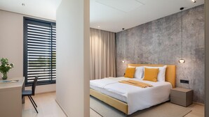 Ein modernes Schlafzimmer mit Bett, Nachttischen, Schreibtisch und Stuhl.