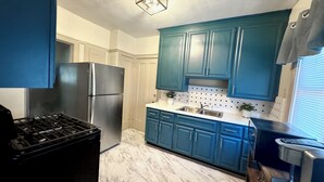 A kitchen with blue cabinets, a stainless steel refrigerator, and a gas stove. - Farmhouse In The City CLE Clinic-Long Stays Welcome - 2bd/1bth WiFi, Full Kitch (Shaker Heights)