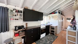 Une cuisine compacte dotée d’un îlot central, de meubles en bois et d’une cuisinière intégrée.