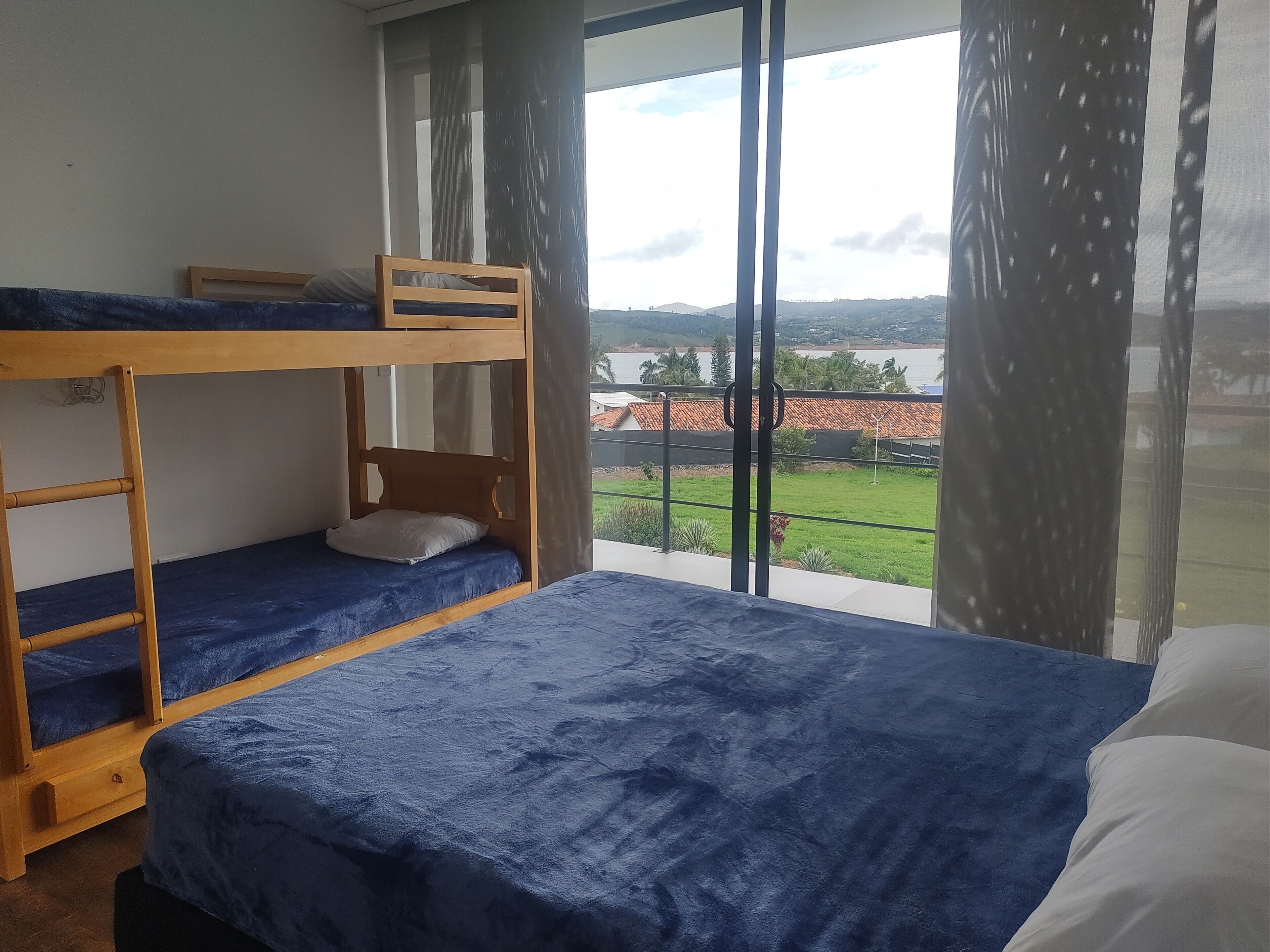Quarto com beliches e uma grande janela com vista para uma paisagem deslumbrante.