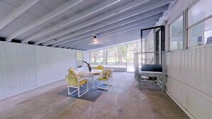A covered outdoor area with a table and chairs, a flag, and a security camera. - MANATEE MANOR, Swim with Manatees! 3bdrm 2 bth home Crystal River with PET Bdrm! (Crystal River)