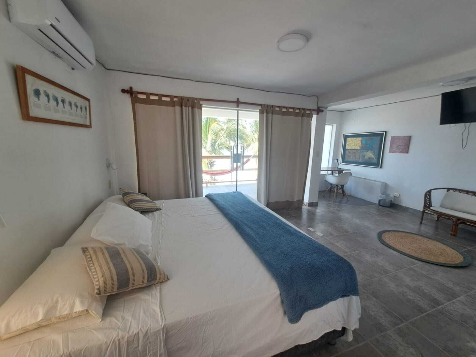Habitación de hotel con cama, televisión, escritorio y vistas al exterior.