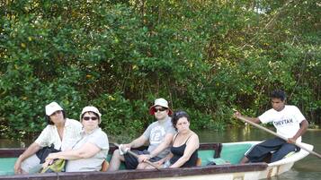 Un grupo de personas en una barca en un río rodeado de vegetación densa.
