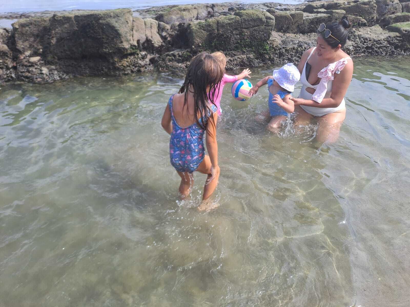 En strandscene med klippeformationer og klart vand.