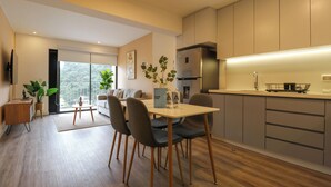 Una cocina moderna con comedor, que cuenta con un ventanal grande, armarios empotrados y una isla central.