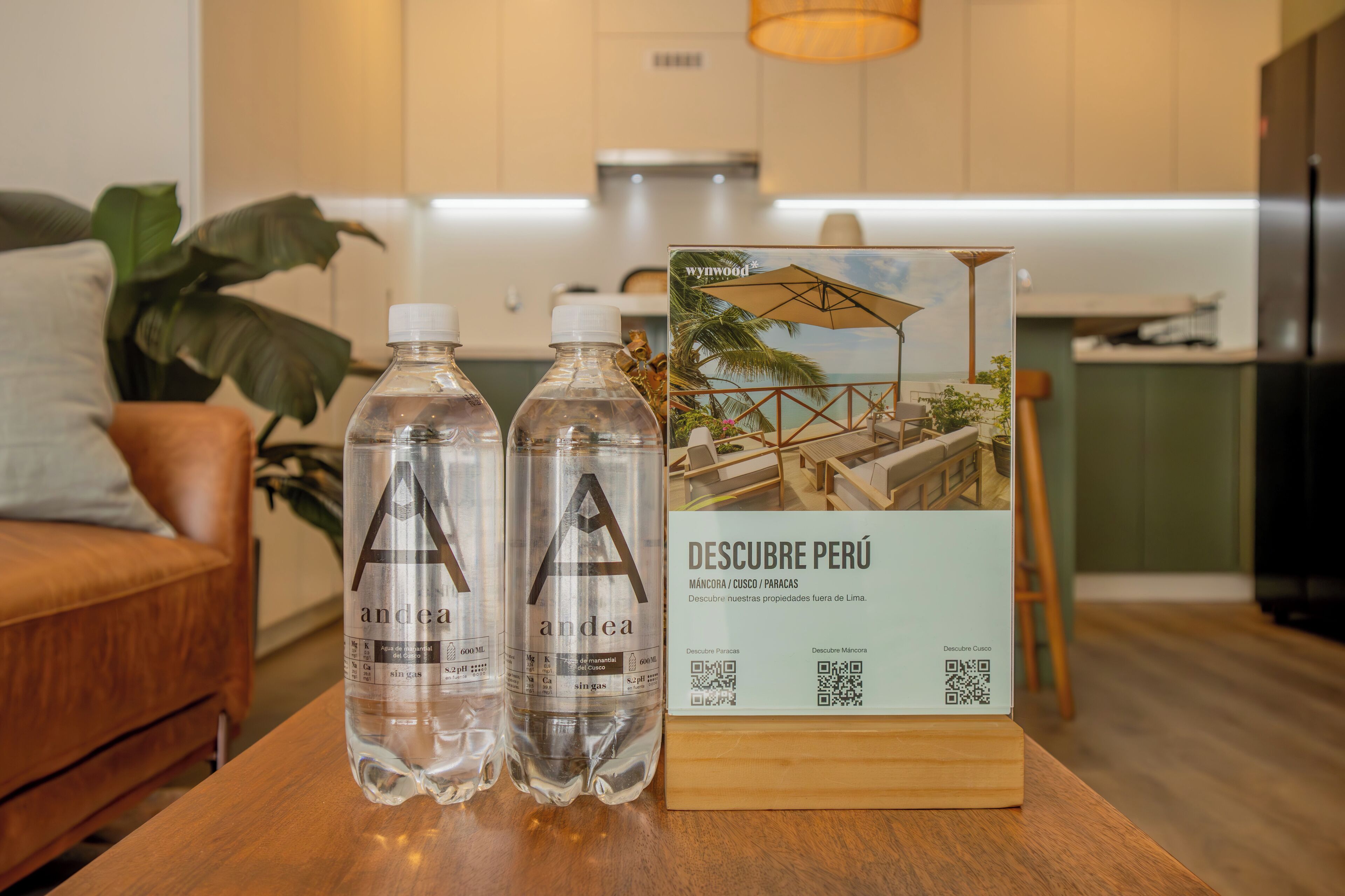 Two water bottles on a wooden table with a QR code and a sign for 'Wynwood' hotel.