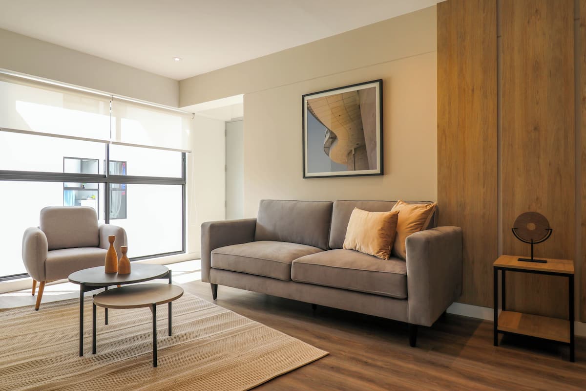 A modern living room with a sofa, coffee table, and a small side table.