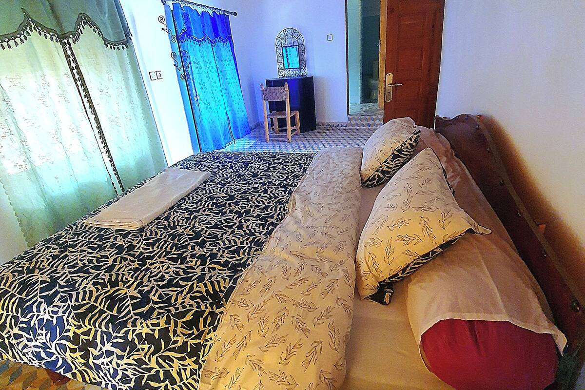 Ein Zimmer mit einem Bett, einem Sessel und einem kleinen Tisch.