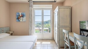 Ein Hotelzimmer mit Bett, Schreibtisch und Blick ins Freie.