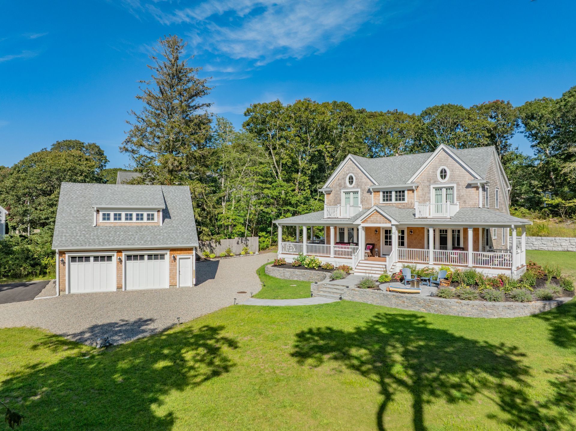 A two-story house with a garage, a covered porch, and a landscaped front yard.