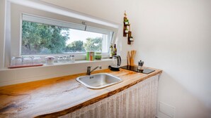 A kitchen with a window, a sink, and a wooden countertop.