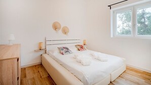 A bedroom with a bed, bedside tables, a window, and a view of trees. - GuestHost - Cozy apartment that accommodates 5 people, located in the quiet countryside of Monopoli, in a villa surrounded by one hectare of centuries-old olive trees. The accommodation, with parking included, offers large open spaces, a patio with barbe (Monopoli)