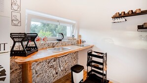 A compact kitchen with a window, a sink, a kettle, and a coffee machine. - GuestHost - Cozy apartment that accommodates 5 people, located in the quiet countryside of Monopoli, in a villa surrounded by one hectare of centuries-old olive trees. The accommodation, with parking included, offers large open spaces, a patio with barbe (Monopoli)