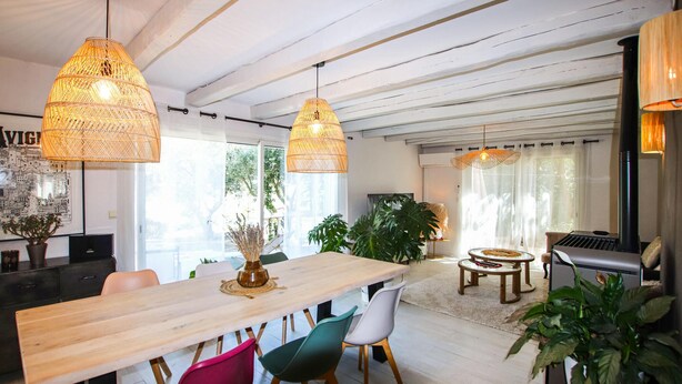 A modern living room with a wooden dining table, colorful chairs, and hanging wicker lamps. - Cozy home in Rochefort du gard (Rochefort du gard)