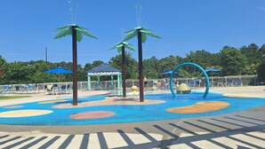 A water play area with palm trees, a gazebo, and a pool with sun loungers.