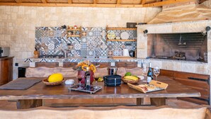 A rustic kitchen with a stone wall, wooden beams, and a tiled backsplash. - Villa Tanja by Interhome (Zadar)