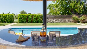 A poolside bar with a bottle of Aberlour whisky, glasses, and a cheese board. - Villa Tanja by Interhome (Zadar)