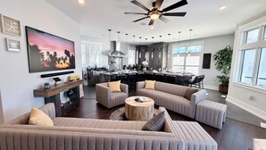 Amplia sala de estar con un sofá modular grande, una mesa de centro y un televisor montado en la pared.