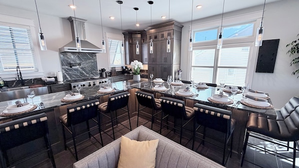 A modern kitchen with a central island, dark cabinetry, and pendant lighting. - New 4,500 Sq.ft. 14 Guests, 5 Bed, 5 Bath, SkyDeck, Spa, Elevator, Docks, WiFi. (Middle Township)