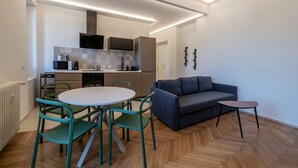 A modern kitchen with a dining area, a sofa, and a small table. - GuestHost - Comfortable apartment located on the seventh floor, of nine in total, equipped with a lift (NOT suitable for disabled people). There are steps at the entrance.In 65 m2 of space it accommodates 2 people with a double bedroom.The location is ex (Roma)