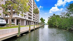 Un hotel frente al agua con vista al canal, un puente peatonal y un estacionamiento.
