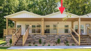 A two-story house with a covered porch, stone steps, and a wooden railing. - Modern Casita w/Outdoor Tub- Unit B (Madison)