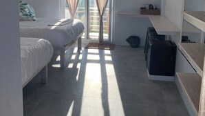 A bedroom with two beds, a desk, and a wardrobe. - Crown Malapascua (Daanbantayan)