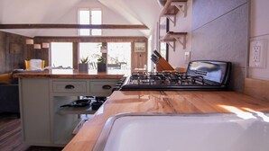 Une cuisine avec un plan de travail en bois, une cuisinière et un évier.