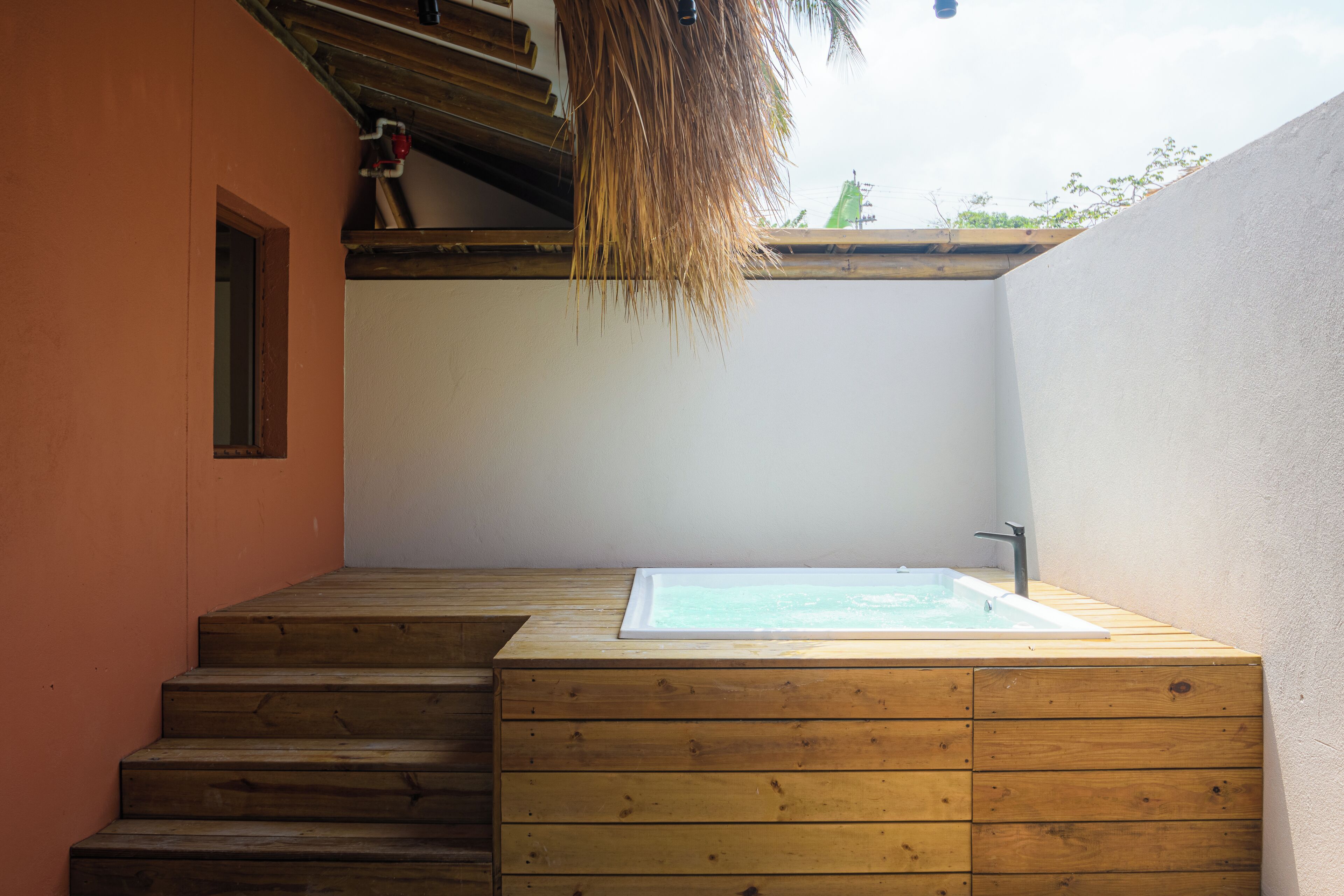 Una escalera de madera conduce a un área de spa con una bañera de hidromasaje.